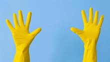 Handen in gele handschoenen steken in de lucht